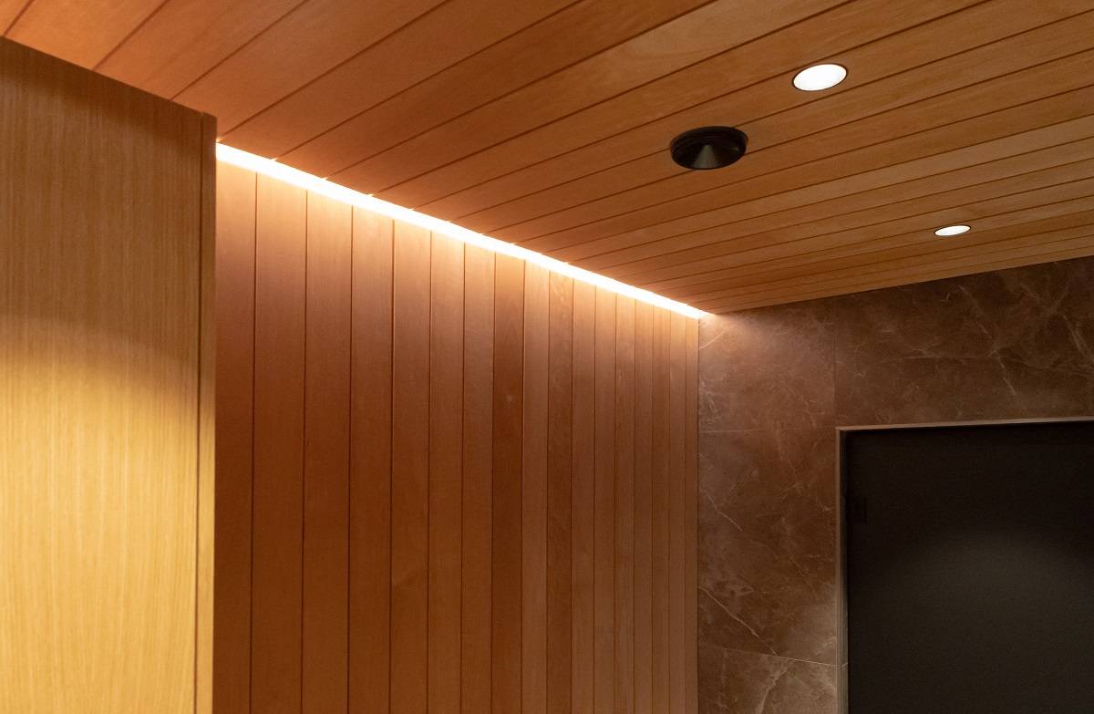 Se ha dejado un hueco de unos 8 cm en el revestimiento de madera, lo que permite que la tira de iluminación LED encaje bien en la abertura.